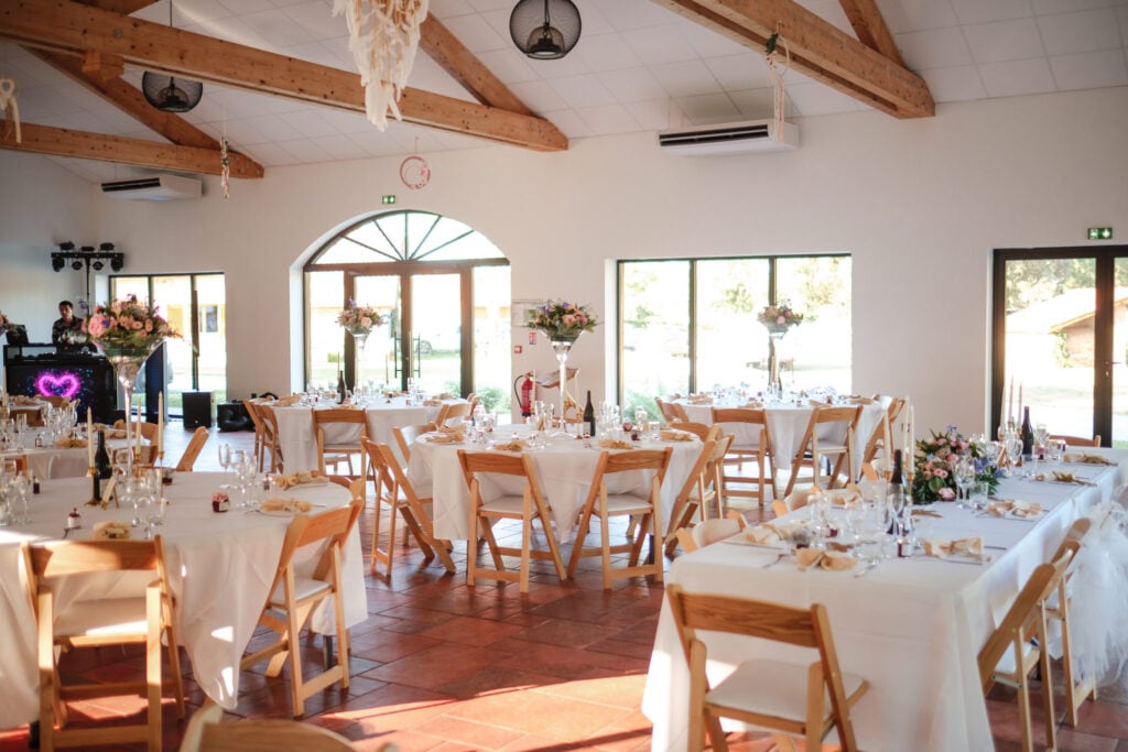 Comment choisir son lieu de mariage au Pays basque ou dans les Landes ? Une salle de réception avec des tables dressées et de grandes ouvertures