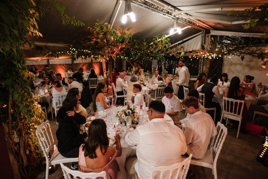 Mariage aux Collines Iduki Les invités réunis pour le dîner de mariage sous les guirlandes lumineuses.