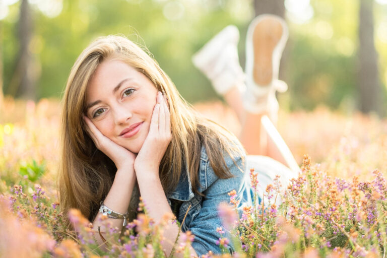 Une femme blonde sourit en extérieur