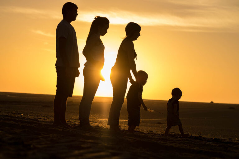 Silhouettes de parents et enfants au soleil couchant