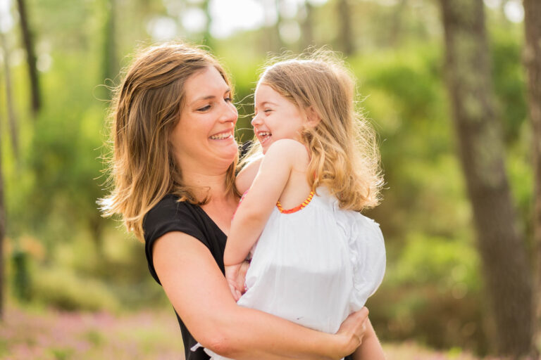 Une mère et sa fille se sourient dans un jardin
