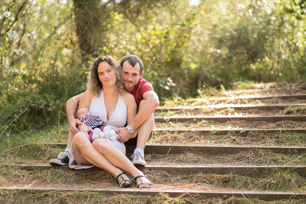 Une famille assise sur un escalier en pierre dans un jardin