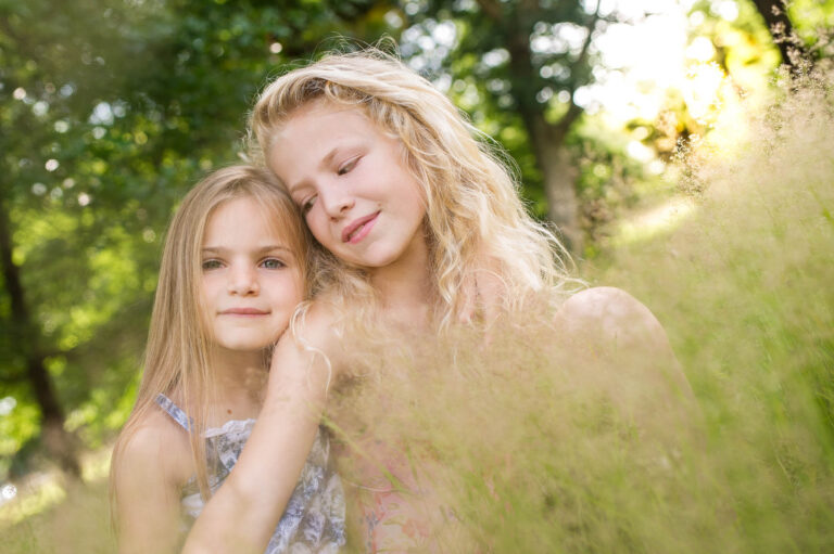 Une enfant blonde sourit dans la verdure
