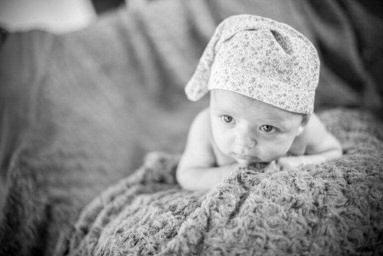 Un bébé emmitouflé dans une couverture, en noir et blanc